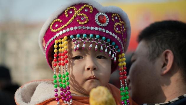 A boy eats corn in a park during the Spring Festival holidays in Beijing. During the holidays, families make it a point to eat together and lavish meals are cooked. (Nicolas ASFOURI / AFP)
