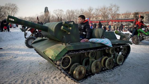 A boy plays in a tank at a Spring Festival fair. The festival is celebrated across China. (Nicolas ASFOURI / AFP)