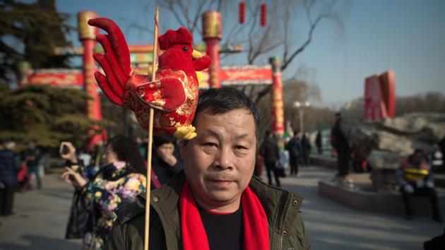 A man holds a rooster decoration at a Spring Festival fair in Beijing. This is the Year of the Rooster, the tenth animal in the Chinese zodiac, which is characterised by intelligence and punctuality. (Nicolas ASFOURI / AFP)