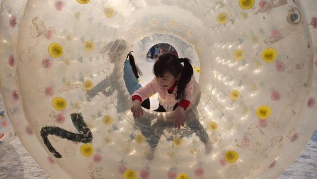 Millions of Chinese are celebrating Spring Festival, the most important holiday on the Chinese calendar, which this year marks the beginning of the Year of the Rooster. Girls play inside an inflated device at an amusement fair in a park during the Spring Festival holiday. (Nicolas ASFOURI / AFP)