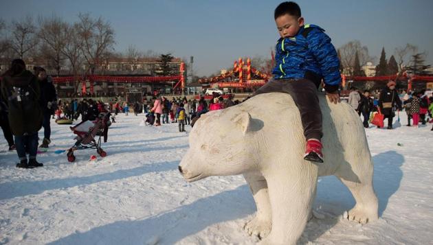 A boy sits on a sculpture of a polar bear at an amusement fair during the Spring Festival holidays in Beijing. The Chinese government gives seven days of holidays for the Spring Festival. (Nicolas ASFOURI / AFP)