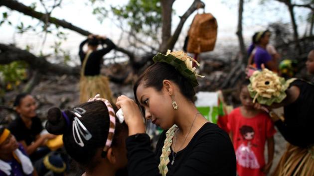 A Malaysian indigenous Mah Meri tribeswoman (centre) applies makeup on a girl as they prepare for the Puja Pantai ritual, a thanksgiving ritual praying to the spirits of the seas, in Pulau Carey on the outskirts of Kuala Lumpur on February 1, 2017. (Manan VATSYAYANA / AFP)