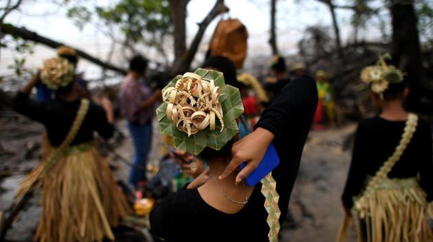 A Malaysian indigenous Mah Meri tribalwoman (C) ties her necklace before the start of the "Puja Pantai" ritual, a thanksgiving ritual praying to the spirits of the seas, in Pulau Carey on the outskirts of Kuala Lumpur on February 1, 2017. (Manan VATSYAYANA / AFP)