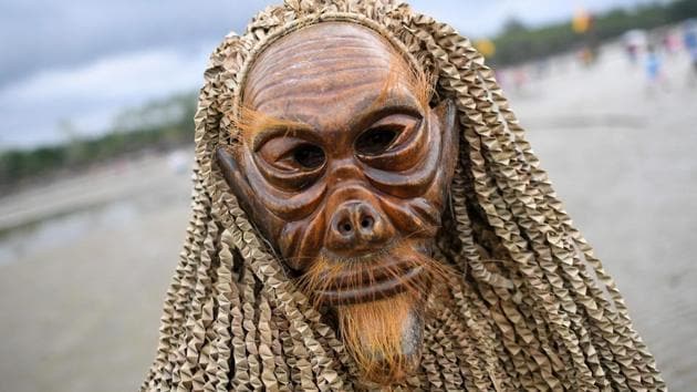 A Malaysian indigenous Mah Meri tribesman wears a traditionally crafted mask during the Puja Pantai ritual, a thanksgiving ritual praying to the spirits of the seas, in Pulau Carey on the outskirts of Kuala Lumpur on February 1, 2017. (Manan VATSYAYANA / AFP)