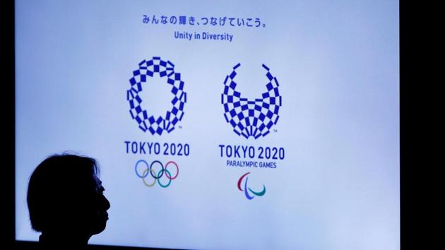 A woman is silhouetted against a monitor showing Tokyo 2020 Olympics and Paralympics emblems during the Olympic and Paralympic flag-raising ceremony at Tokyo Metropolitan Government Building on September 21, 2016.(REUTERS)