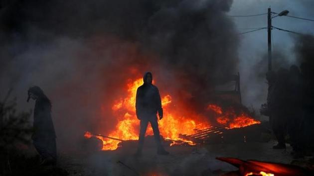 Protesters stand next to fire at the entrance to the Israeli settler outpost of Amona in the occupied West Bank. (Reuters Photo) Protesters stand next to fire at the entrance to the Israeli settler outpost of Amona in the occupied West Bank. (Reuters Photo)