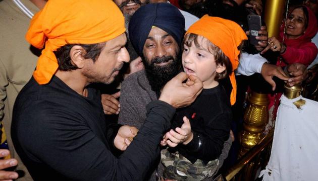 Shah Rukh Khan giving 'parshad' to his son AbRam while paying obeisance at Golden temple in Amritsar. (PTI)
