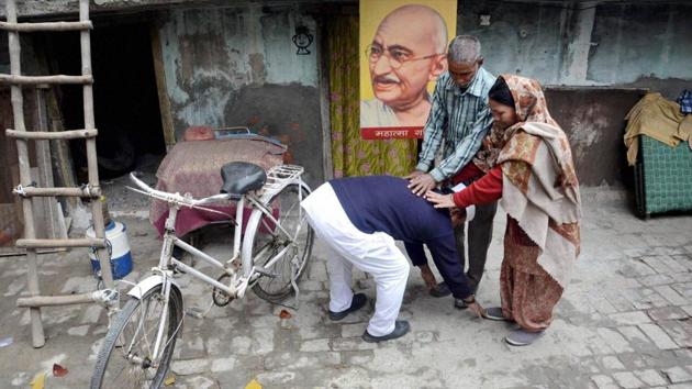 Sham Lal Gandhi, a follower of Mahatma Gandhi's philosophy, seeking blessings from his parents before filing his nomination papers for the upcoming Assembly elections as an independent candidate in Amritsar. (PTI)