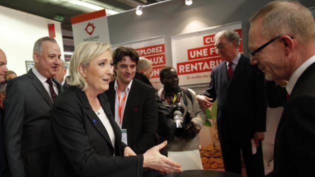 Far-right leader and candidate for next spring presidential elections Marine le Pen, centre left, shakes hands as she visits the Entrepreneur Fair in Paris, France.(AP Photo)