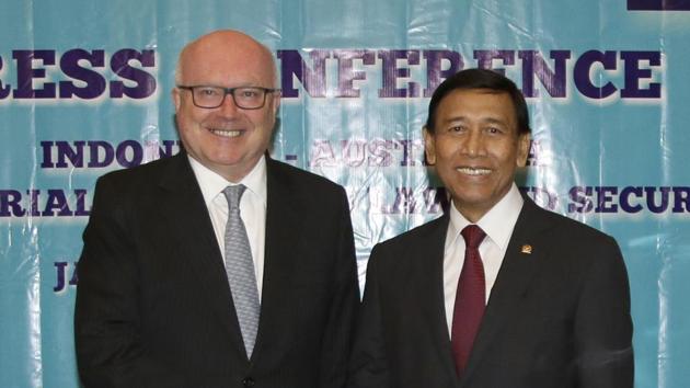 Australia's attorney general George Brandis, left, and Indonesian coordinating minister for security Wiranto pose for photographers as they shakes hands at the end of a press conference after their meeting at the ministerial council meeting on law and security in Jakarta, Indonesia, Feb 2.(AP Photo)