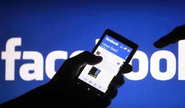 A smartphone user shows the Facebook application on his phone.(REUTERS)