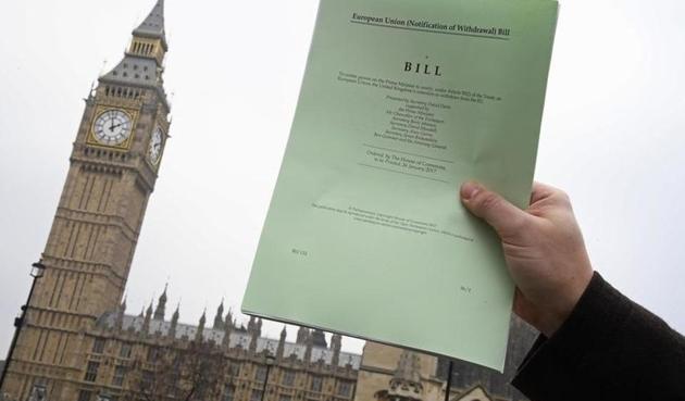 A journalist holds a copy of the Brexit Article 50 bill in front of the Houses of Parliament in London.(Reuters)