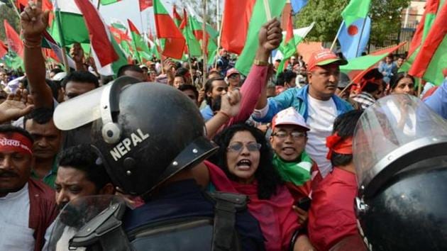 Nepalese activists from the Federal Alliance (members of the Madhesi and ethnic communities) chant slogans as police stand guard during a demonstration against the government in Kathmandu on May 14, 2016. (AFP File) Nepalese activists from the Federal Alliance (members of the Madhesi and ethnic communities) chant slogans as police stand guard during a demonstration against the government in Kathmandu on May 14, 2016. (AFP File)