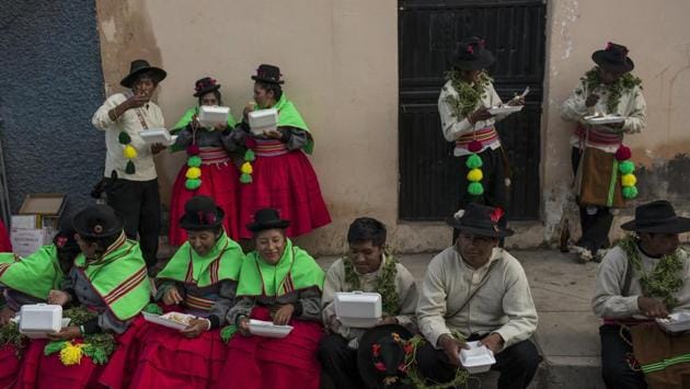Dancers eat lunch after performing during Virgin of Candelaria celebrations in Puno, Peru. In addition to adults, young children dance with their families in groups of as many as 400 people, including musicians who play flutes and other traditional instruments. (Rodrigo Abd / AP)