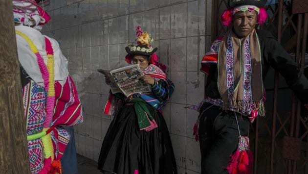 A dancer reads a newspaper while waiting to perform during Virgin of Candelaria celebrations in Puno, Peru. As many as 40,000 villagers are expected to gather for the annual festival and show their respect for the patron saint of the communities along the shores of Lake Titicaca. (Rodrigo Abd / AP)