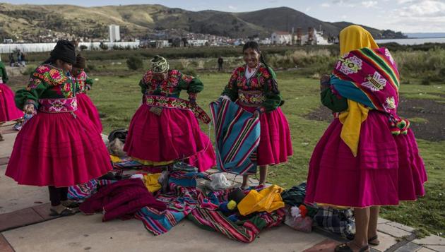 Dancers put on their costumes near the shore of Lake Titicaca prior to their performance for Virgin of Candelaria celebrations in Puno, Peru. Some competing groups wear shoes made of alpaca skin, collars hung with ears of corn and hats adorned with old coins or the bright-colored feathers of Amazonian birds. (Rodrigo Abd / AP)