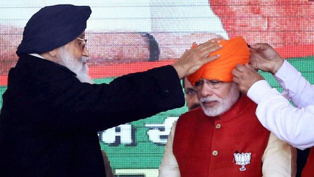 Prime Minister Narendra Modi is offered a turban by Punjab Chief Minister Parkash Singh Badal at the Vijay Sankalp Yatra rally for Punjab Assembly elections in Jalandhar. (PTI)