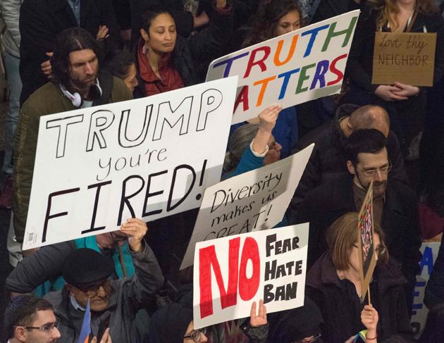 People hold up signs during a protest against US President Donald Trump's immigration rules at the Regan National Airport in Arlington, Virginia on February 1. (AFP) People hold up signs during a protest against US President Donald Trump's immigration rules at the Regan National Airport in Arlington, Virginia on February 1. (AFP)