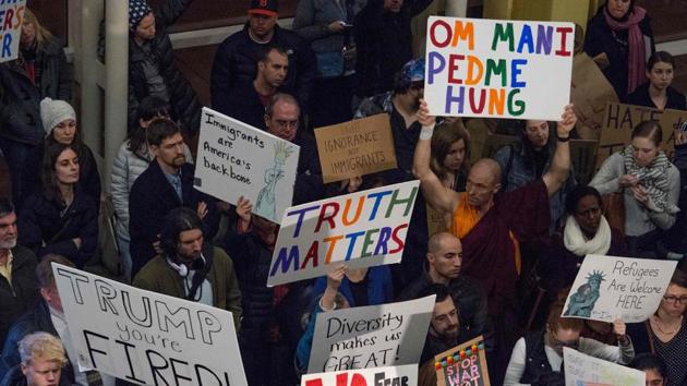 People hold up signs during a protest against US President Donald Trump's immigration rules at the Regan National Airport in Arlington, Virginia. (AFP Photo) People hold up signs during a protest against US President Donald Trump's immigration rules at the Regan National Airport in Arlington, Virginia. (AFP Photo)