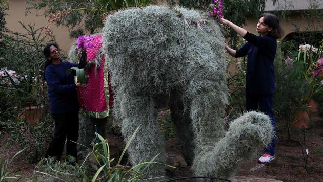 Employees pose near an elephant display of orchids. (AFP photo) Employees pose near an elephant display of orchids. (AFP photo)