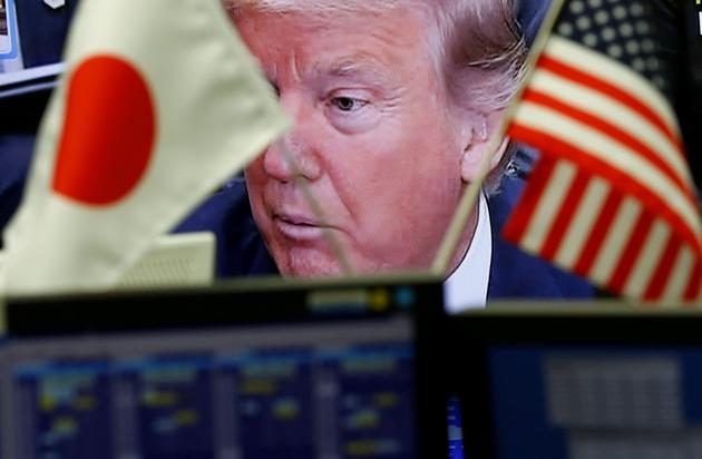 A TV showing US President Donald Trump is seen through national flags of the US and Japan at a foreign exchange trading company in Tokyo. (REUTERS) A TV showing US President Donald Trump is seen through national flags of the US and Japan at a foreign exchange trading company in Tokyo. (REUTERS)
