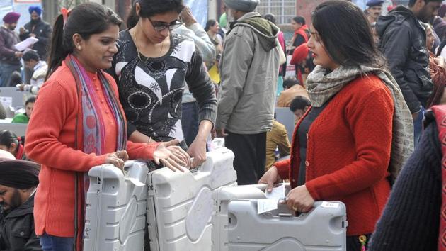 Poll staff members with EVMs at Khalsa College for Women, in Ludhiana on Friday. (Gurminder Singh/HT)