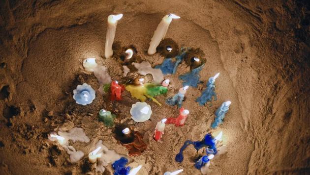 Candles lit to honor the African sea goddess Yemanja are propped in the sand in Montevideo, Uruguay. (Matilde Campodonico / AP)