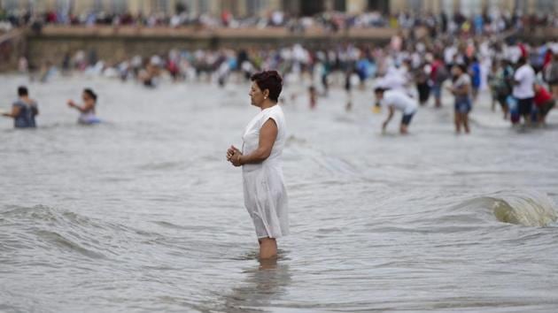A woman stands in shallow ocean waters honoring the African sea goddess Yemanja, in Montevideo, Uruguay, Thursday, Feb. 2, 2017. Thousands of worshippers come to the beach on Yemanja's feast day, bearing candles, flowers, perfumes and and fruit to show their gratitude for her blessings. The celebration coincides with the Roman Catholic feast day of the Virgin of Candelaria, marked Feb. 2. (Matilde Campodonico / AP)