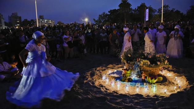 A woman dances around an offering for the African sea goddess Yemanja, in Montevideo, Uruguay, Thursday, Feb. 2, 2017. (Matilde Campodonico / AP)