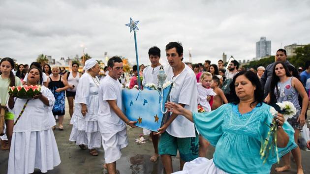 Worshippers carry a boat filled with offerings for the African sea goddess Yemanja, at a beach in Montevideo, Uruguay, Thursday, Feb. 2, 2017. Thousands of worshippers come to the beach on Yemanja's feast day, bearing candles, flowers, perfumes and fruit to show their gratitude for her blessings. (Matilde Campodonico / AP)