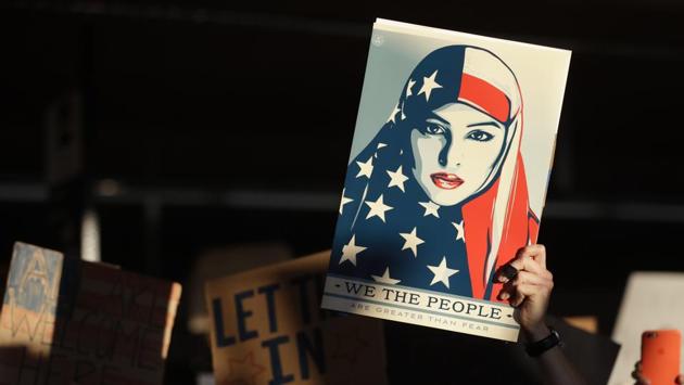 A protester holds up a sign at San Francisco International Airport during a demonstration to denounce President Donald Trump's executive order that bars citizens of seven predominantly Muslim-majority countries from entering the US. (Marcio Jose Sanchez / AP)