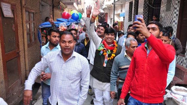 SP-Cong’s Sunil Chaudhary (garlanded) campaigns with his supporters in Noida.