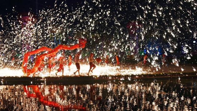 People perform a fire dragon dance under a shower of sparks from molten iron during the Chinese Lunar New Year holidays, in Wuhan, China. (REUTERS)