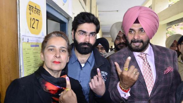 Navjot Singh Sidhu with his wife, former MLA Navjot Kaur Sidhu. and son Karan Sidhu, showing their inked fingers after casting their votes at a polling both in SR Government College, Amritsar, on Saturday, February 4.(Sameer Sehgal/HT)