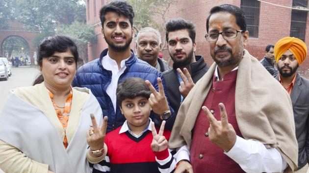 BJP candidate Anil Joshi with his family showing their inked fingers out of polling booth at Government Medical College, Amritsar on Saturday. (Sameer Sehgal/HT Photo)