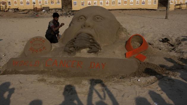 Artist Narayan Sahu makes a sand sculpture on the eve of World Cancer Day, at Juhu beach on Friday.(Satish Bate/HT PHOTO)