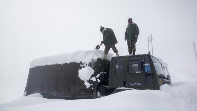 Indian Army soldiers clear snow from their stranded vehicle near a base camp in Gulmarg in Kashmir on Jan 27, 2017. Authorities have issued avalanche warnings for many parts of Kashmir and Himachal Pradesh, as the heavy snowfall has cut off roads, disrupted power and communication lines, and forced the evacuation of hundreds of residents.(AP file photo)