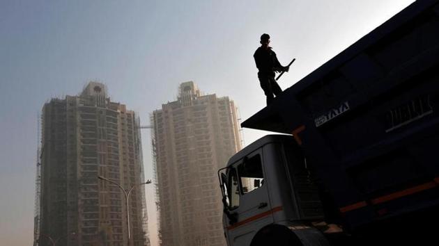 A labourer stands on a truck carrying construction materials at a construction site of residential buildings in Noida on the outskirts of New Delhi.(Reuters file photo) A labourer stands on a truck carrying construction materials at a construction site of residential buildings in Noida on the outskirts of New Delhi.(Reuters file photo)
