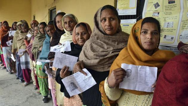 Voters display their election identity cards as they stand in a queue to cast their votes outside a polling station, at Chogawan village, about 20 kilometers from Amritsar, in the northern Indian state of Punjab.(AP Photo)