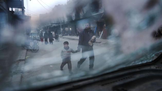 A Syrian man and a child walking in the rebel-held town of Douma, on the eastern outskirts of the capital Damascus. (Abd Doumany/AFP)