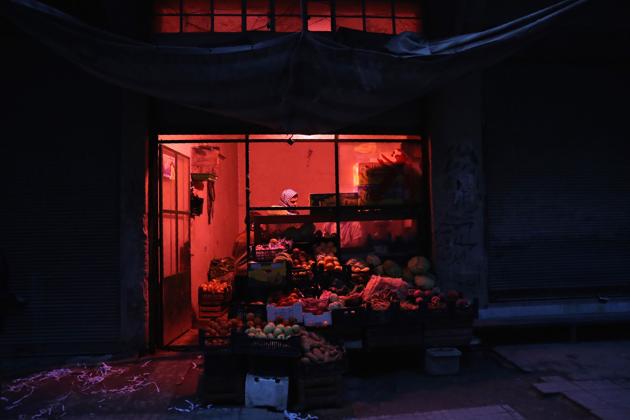 A Syrian vendor works at a vegetable and fruits shop at night. (Abd Doumany/AFP)