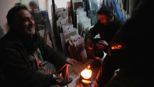 Syrian men sit around a fire at a glass-workshop. (Abd Doumany/AFP)