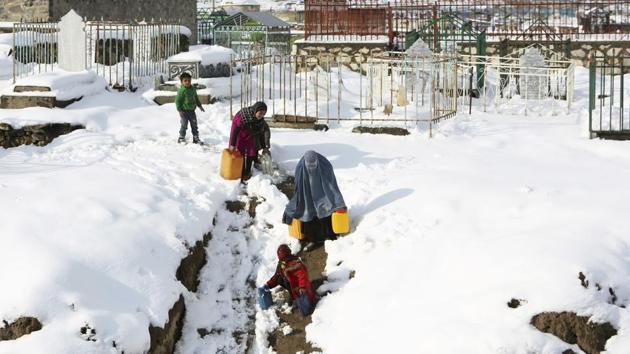 A woman and her children carry containers of water in the snow on the outskirts of Kabul, Afghanistan, on Monday. (AP) A woman and her children carry containers of water in the snow on the outskirts of Kabul, Afghanistan, on Monday. (AP)