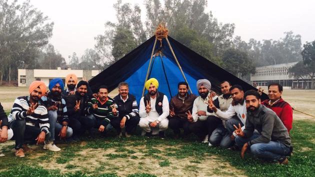 AAP Candidate Nabha Gurdev Singh Mann (centre) with supporters camping outside a 'strongroom' where Electronic Voting Machines have been stored in Patiala on Monday.(HT Photo)