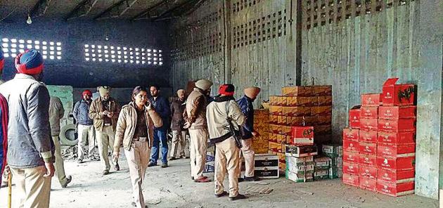 Police officials inspecting the illegally stored cartons of liquor in Jalandhar.(HT File Photo)