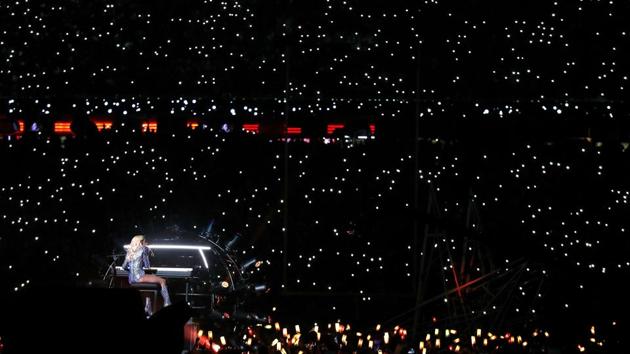 Audience members swinging lights in synchronization — the usual excess that has become a cliche of Super Bowl shows. (AFP)