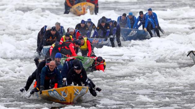 A member of Team Chez Victor falls into the water during the ice canoe race at the Quebec Winter Carnival in Quebec City. (REUTERS)