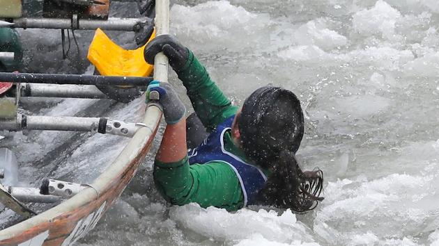 A member of Team Cuisina falls in the water during the ice canoe race at the Quebec Winter Carnival in Quebec City. (REUTERS)