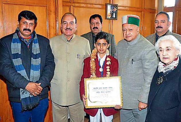 Chief minister Virbhadra Singh presenting the prize money to Praful Sharma of Sarkaghat, Shimla, on Monday.(HT Photo)
