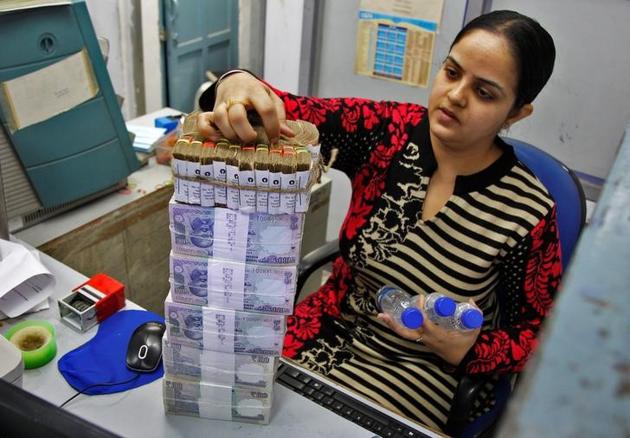 A cashier stacks currency notes inside a bank in Chandigarh, India, November 19, 2016. REUTERS/Ajay Verma/File Photo